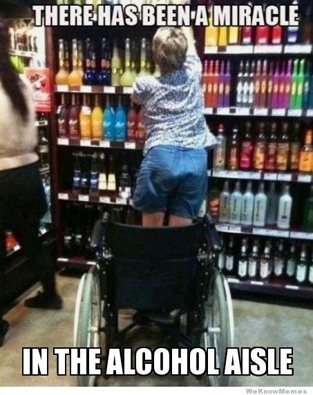  A woman in a wheelchair stands up to reach a bottle of liquor on a tall shelf. The image has the phrase “There has been a miracle in the alcohol aisle” in all caps written across it. 