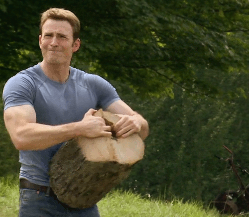 Captain America splitting a large tree stump by hand.